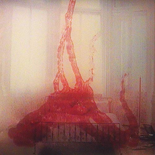 Red, abstract splatter art over a hospital bed in a room.