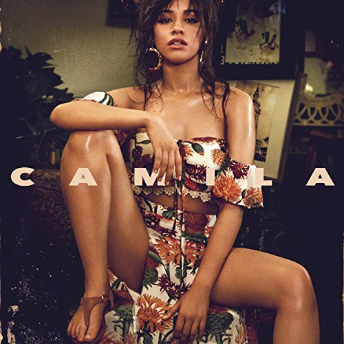 Camila Cabello sits wearing a floral two-piece outfit with the word CAMILA overlaid.