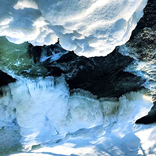 Abstract, icy landscape with a small figure silhouetted at the peak.