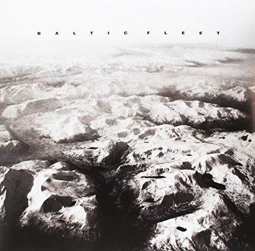 Black and white aerial view of snowy, mountainous terrain; album cover.