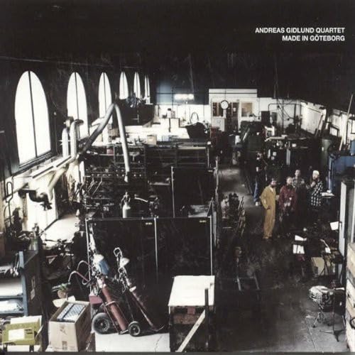 CD cover: interior view of a cluttered workshop with people.