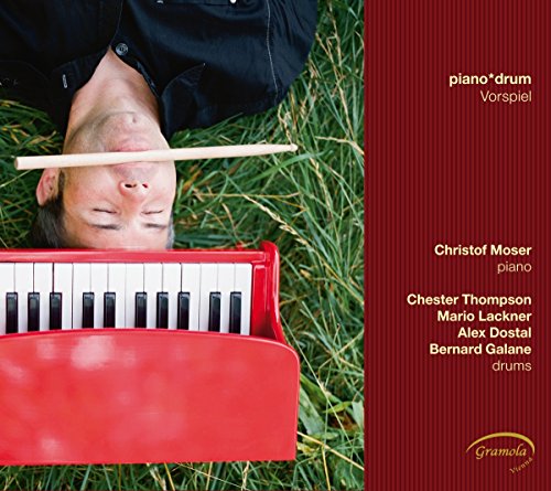 CD cover: man lying with a drumstick over his eyes, red piano.