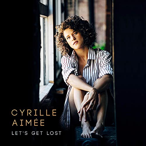 Cyrille Aimee album cover: woman with curly hair sitting by a window.
