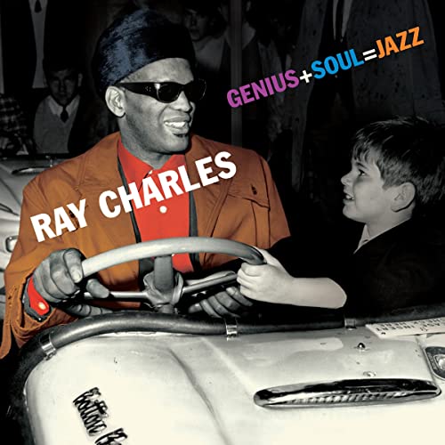 Ray Charles in sunglasses at the steering wheel of a car.