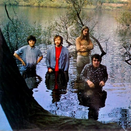 Four men stand waist-deep in water, reflected in the still surface.
