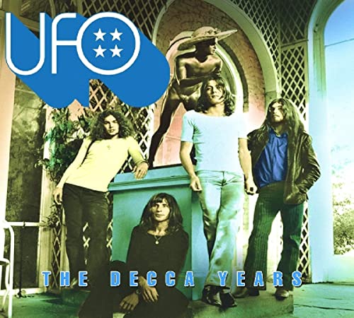 UFO band members pose in front of a statue and arched doorway.