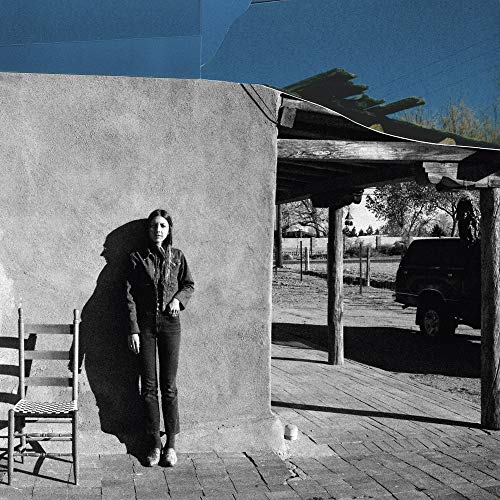 Black and white photo of a woman standing near a building.