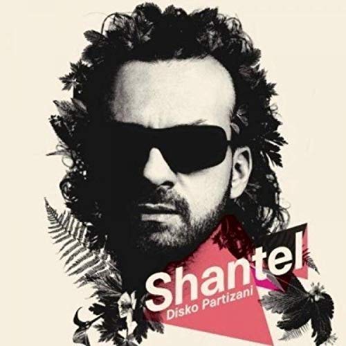 Album cover showing a man with dark sunglasses and curly hair amidst foliage.