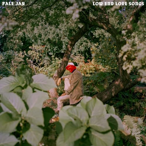 Album cover: person in suit and hat seated under trees.