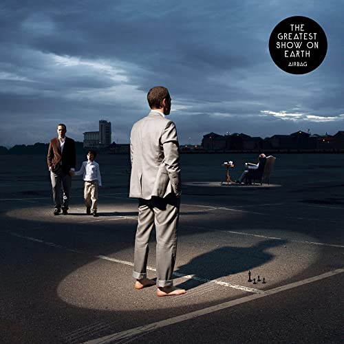 CD cover: two men and a boy stand on an airfield runway.