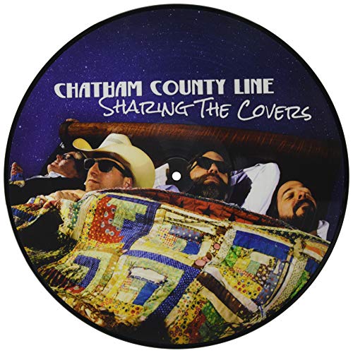 Round vinyl record with a band portrait under a patchwork quilt.