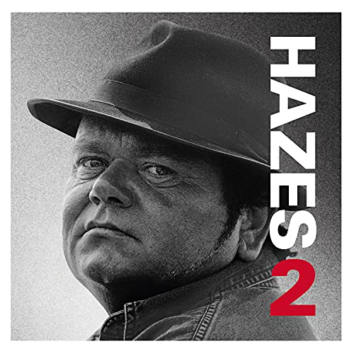 Black and white portrait of Andre Hazes wearing a hat, with red “Hazes 2” text.