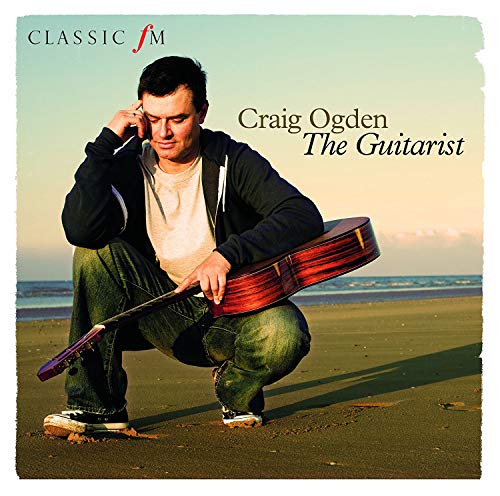 Man crouching with guitar on a beach, album cover for Craig Ogden.