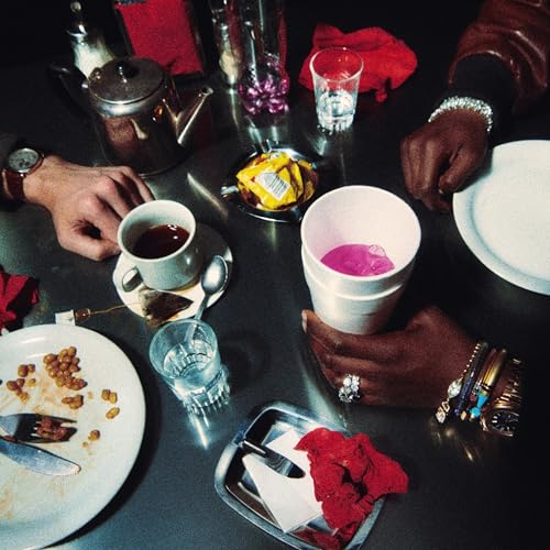 Overhead view of hands, drinks, and food on a metallic surface.