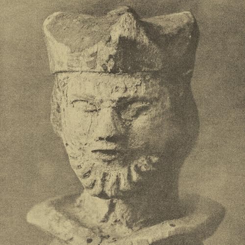 Close-up of a weathered, stone bust with closed eyes and a beard.