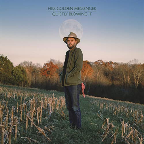 Album cover: man in hat standing in a field, moon above trees.