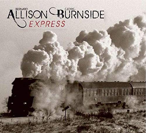 Black and white photo of a steam train emitting large plumes of smoke.