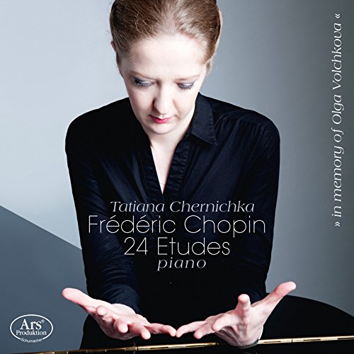 Pianist Tatiana Chernichka in black, hands poised over piano keys.