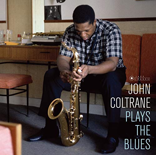 John Coltrane seated, holding a saxophone, album cover image.