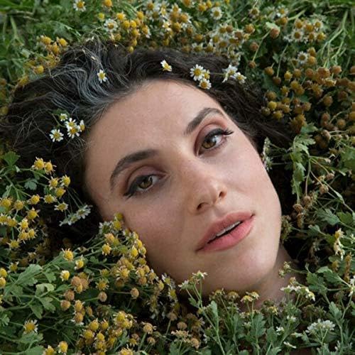 Woman with flowers in her hair, looking directly at the viewer.