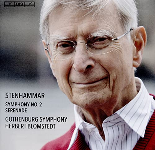 Portrait of conductor Herbert Blomstedt wearing glasses, a white shirt, and a red sweater.