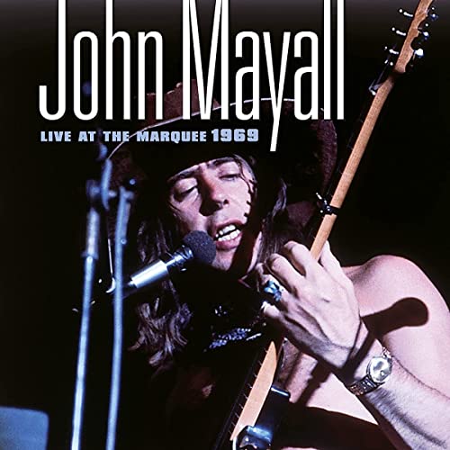 John Mayall performing with a guitar and microphone onstage, 1969.