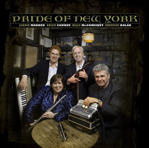 Four musicians with instruments pose in front of a pub interior.