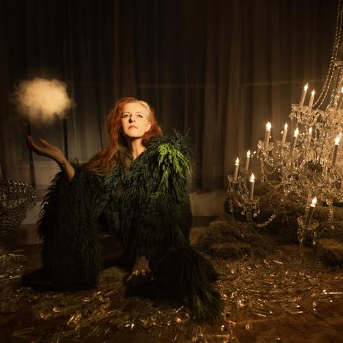 Red-haired woman in a dark, feathery coat amidst broken glass and candles.
