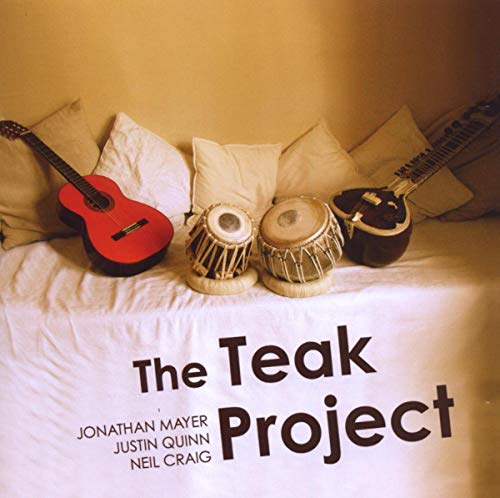 CD cover with guitar, drums, and pillows on a white bedspread.