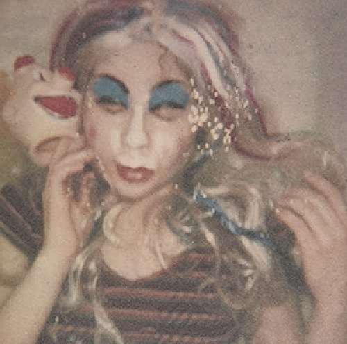 Close-up of a person with colorful makeup and a toy animal.
