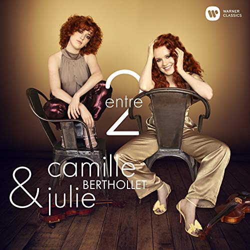 Two red-haired women seated on chairs, with a violin and album title.