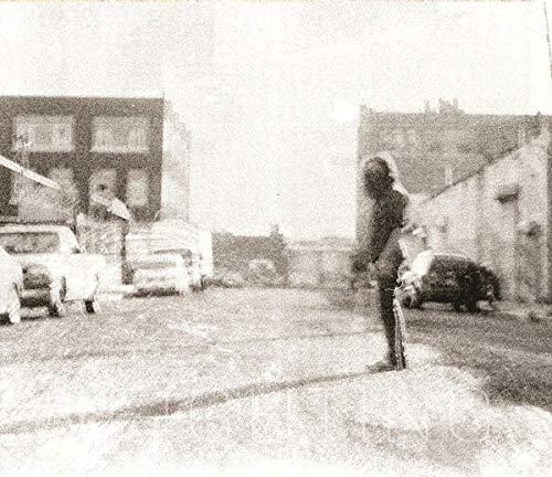 Black and white photo of a person standing in a city street.