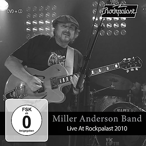 Black and white image of a guitarist performing live on stage.