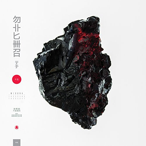 A jagged black mineral with red highlights centered on a white background.