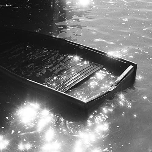 Black and white photo of a small boat on rippling water.