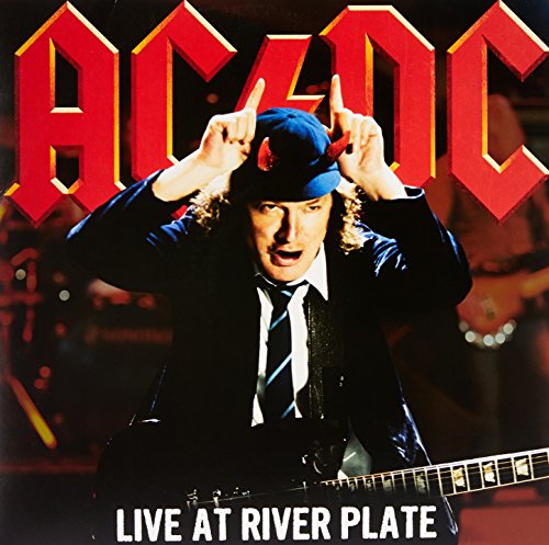 Angus Young wearing devil horns on stage with the AC/DC logo above him.