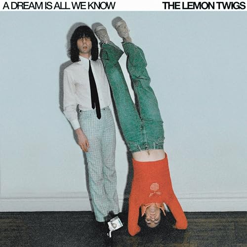 Two people in vintage clothing, one standing and one upside down.