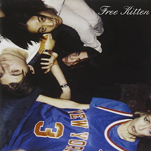 Four people lying on a dark surface, looking at the camera.