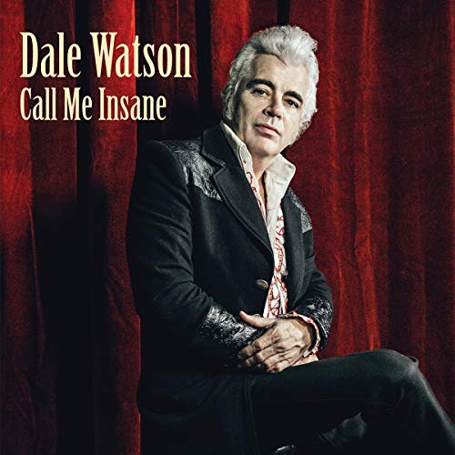 Dale Watson in a black suit against a red curtain background.