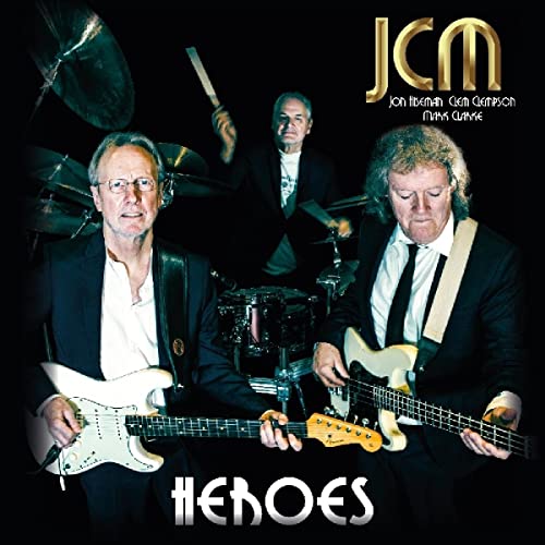 JCM album cover: three musicians with guitars and drums, dark background.