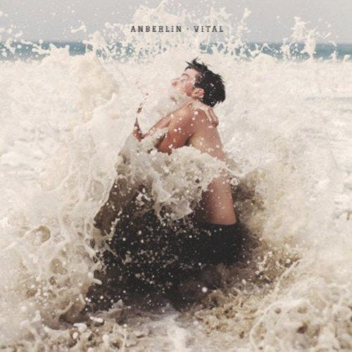 Album cover: man emerging from crashing ocean waves, back view.