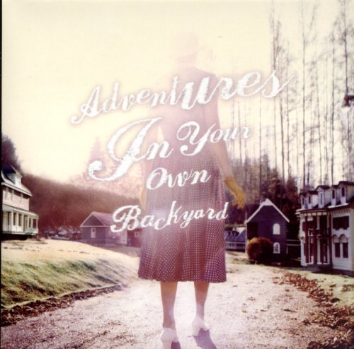 CD cover with a woman walking towards small houses in a landscape.