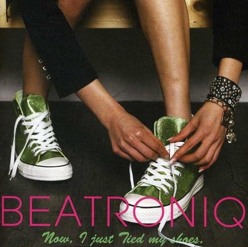Close-up of hands tying green and white high-top sneakers.