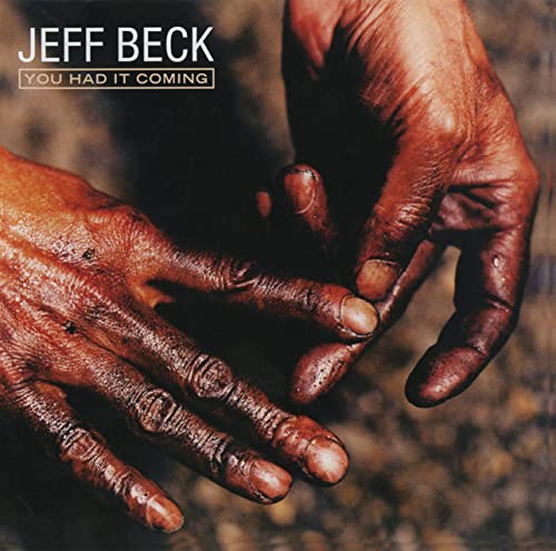Album cover showing two hands covered in dark, gritty substance against a blurred background.