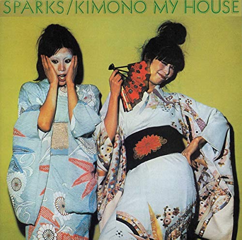 Two women in patterned kimonos pose against a yellow background on this album cover.