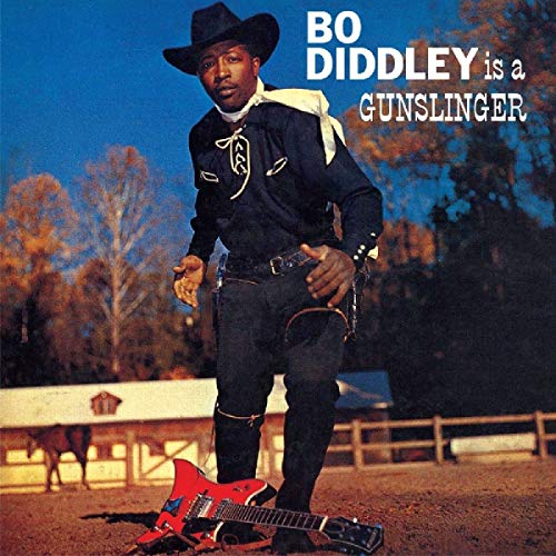Bo Diddley in cowboy attire with a red guitar, album cover.