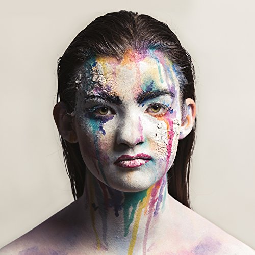 Close-up of a person with colorful, abstract face paint dripping down.