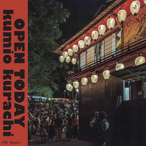 Night scene of a building with lanterns, crowd in foreground.