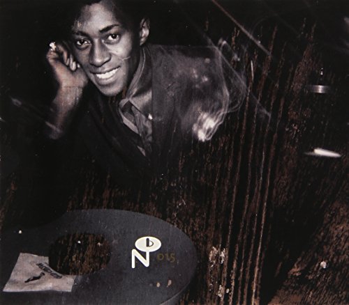 Black and white portrait of a smiling man with a record player.