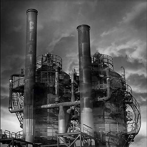 Black and white image of industrial towers and complex piping.